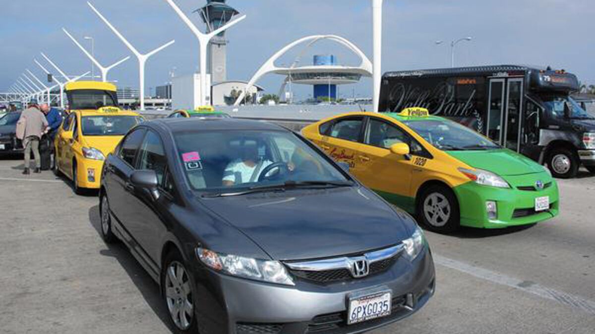 An Uber-Lyft driver queues up alongside taxicab drivers at LAX.