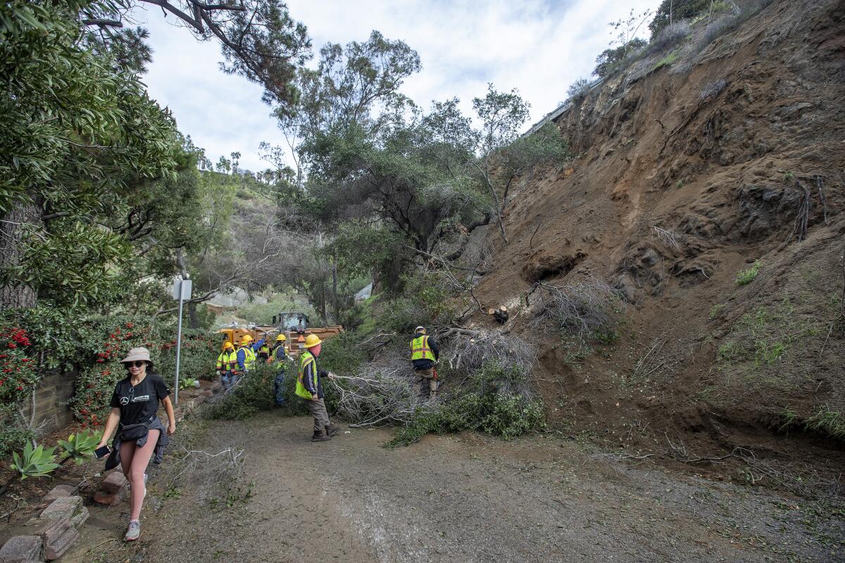 Workers with the city of Los Angeles Bureau of Street Services work to clear a mudslide.