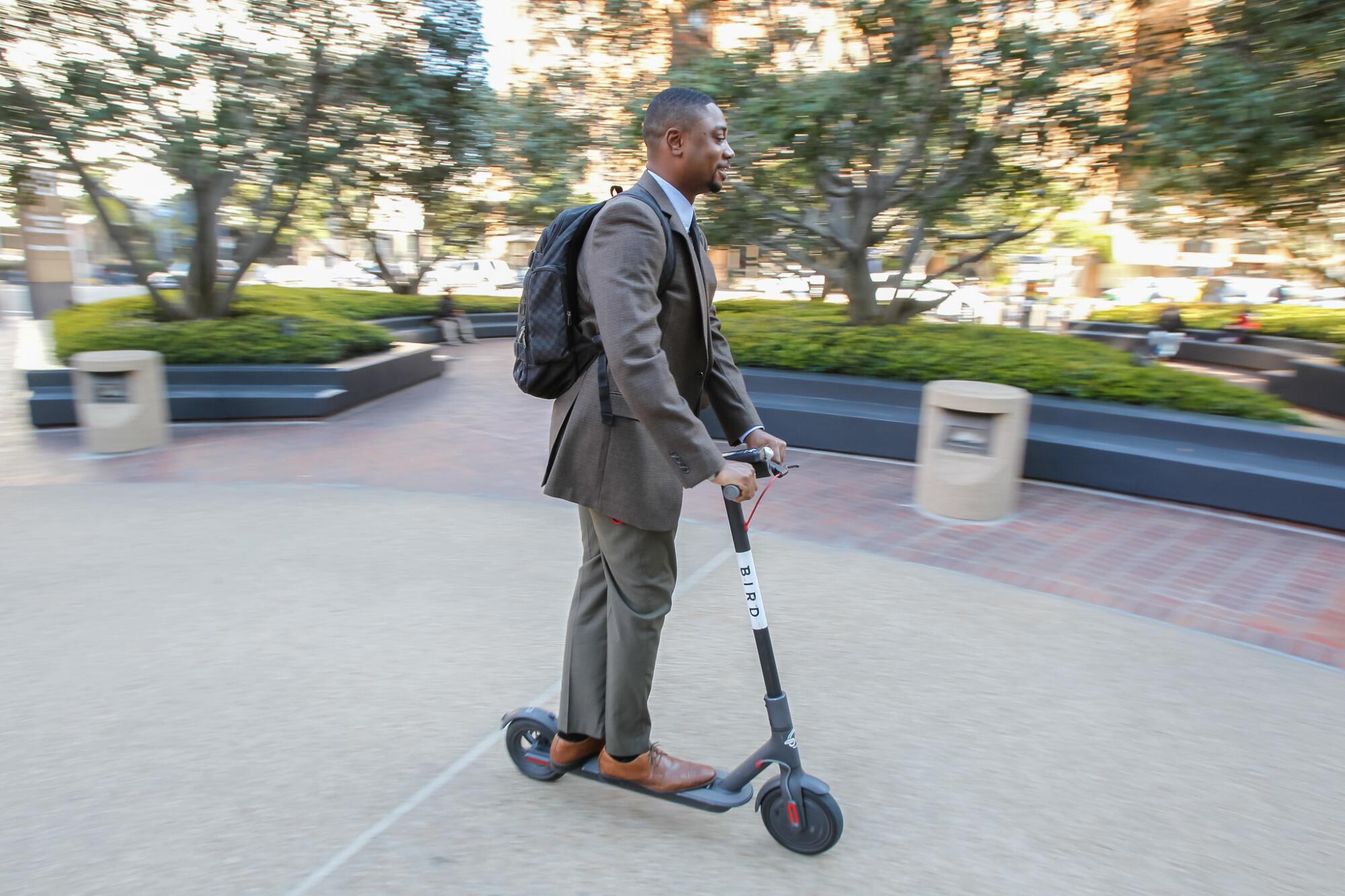 Kelvin Fowler rides a Bird scooter along Broadway Street on Thursday in Downtown San Diego, California.