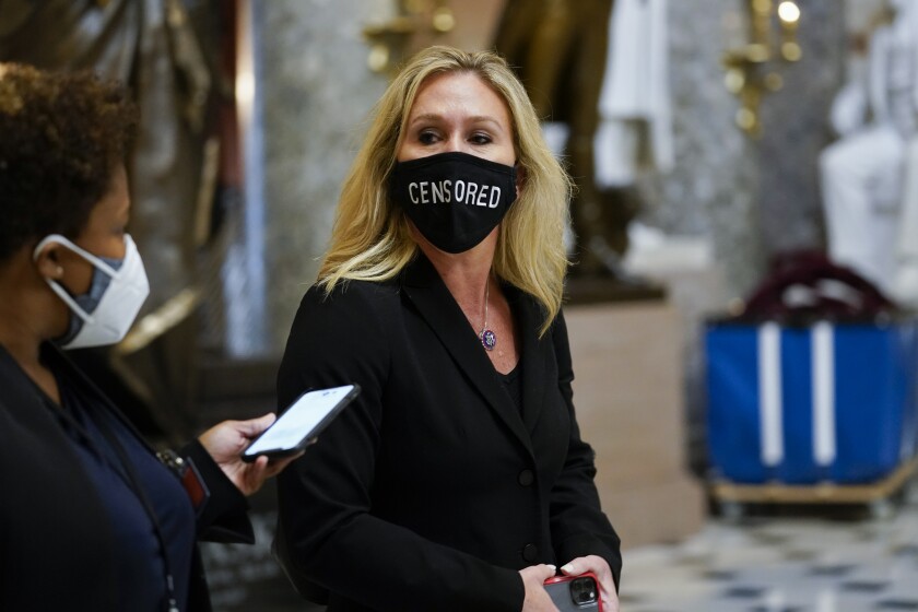 Rep. Marjorie Taylor Greene (R-Ga.) wearing a protective mask that reads "Censored" as she walks through the Capitol.
