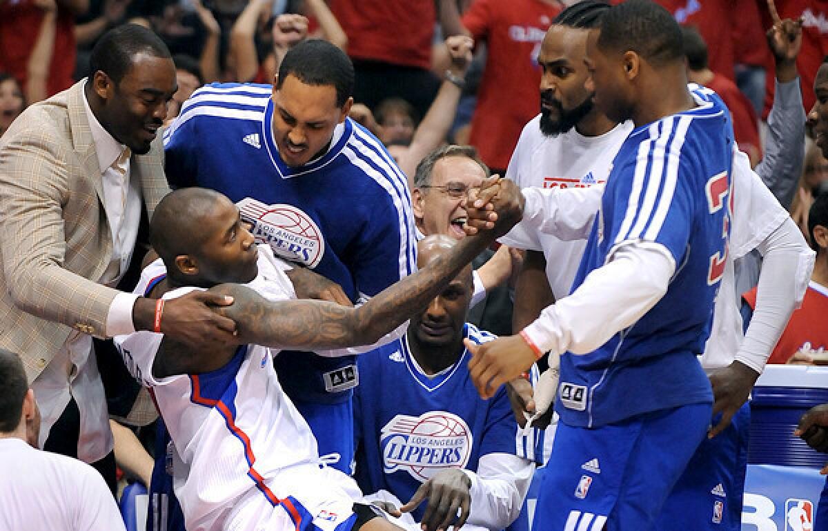 Clippers guard Jamal Crawford is helped by teammate after getting fouled while making a three-point shot in the first half Saturday night.