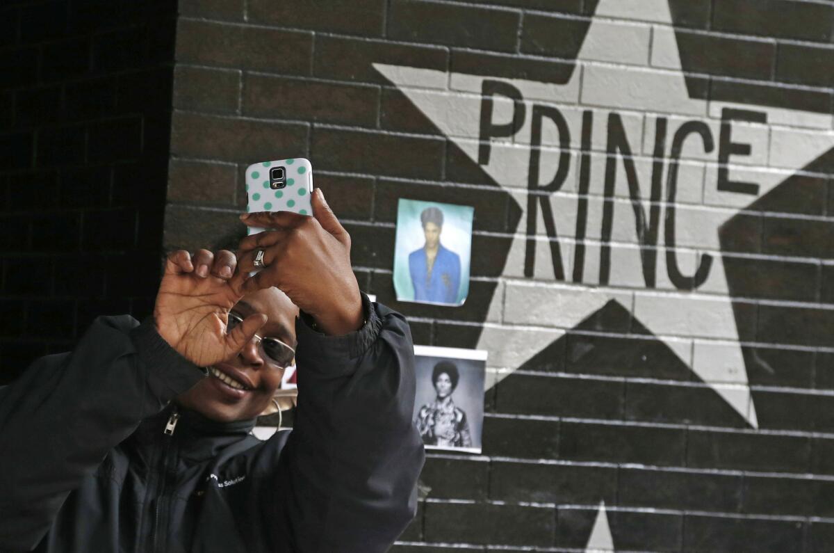 A fan takes a selfie by the Prince star and memorial at First Avenue in Minneapolis on April 22.