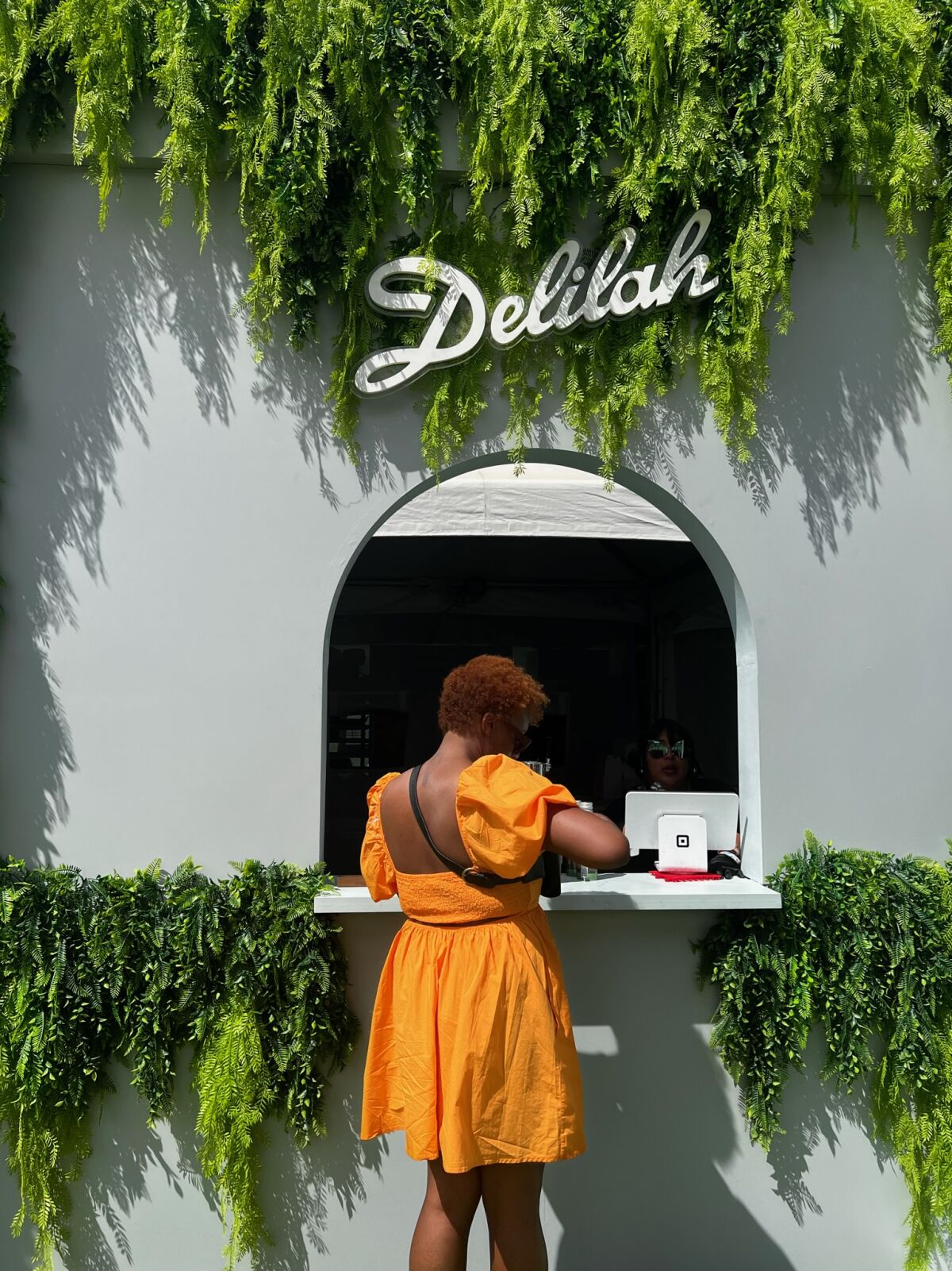 Danielle Dorsey orders a cocktail at the Delilah pop-up bar in the Postmates Retreat at Coachella 2023
