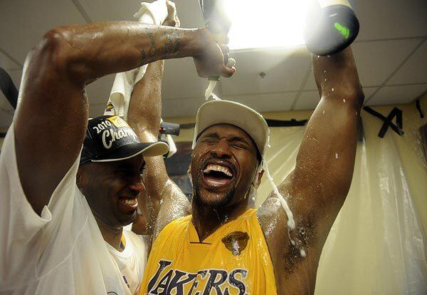 Kobe Bryant helps soak Ron Artest in champagne in the Lakers ' locker room. Bryant earned his fifth championship ring. Artest, who scored 20 points in Game 7, earned his first.