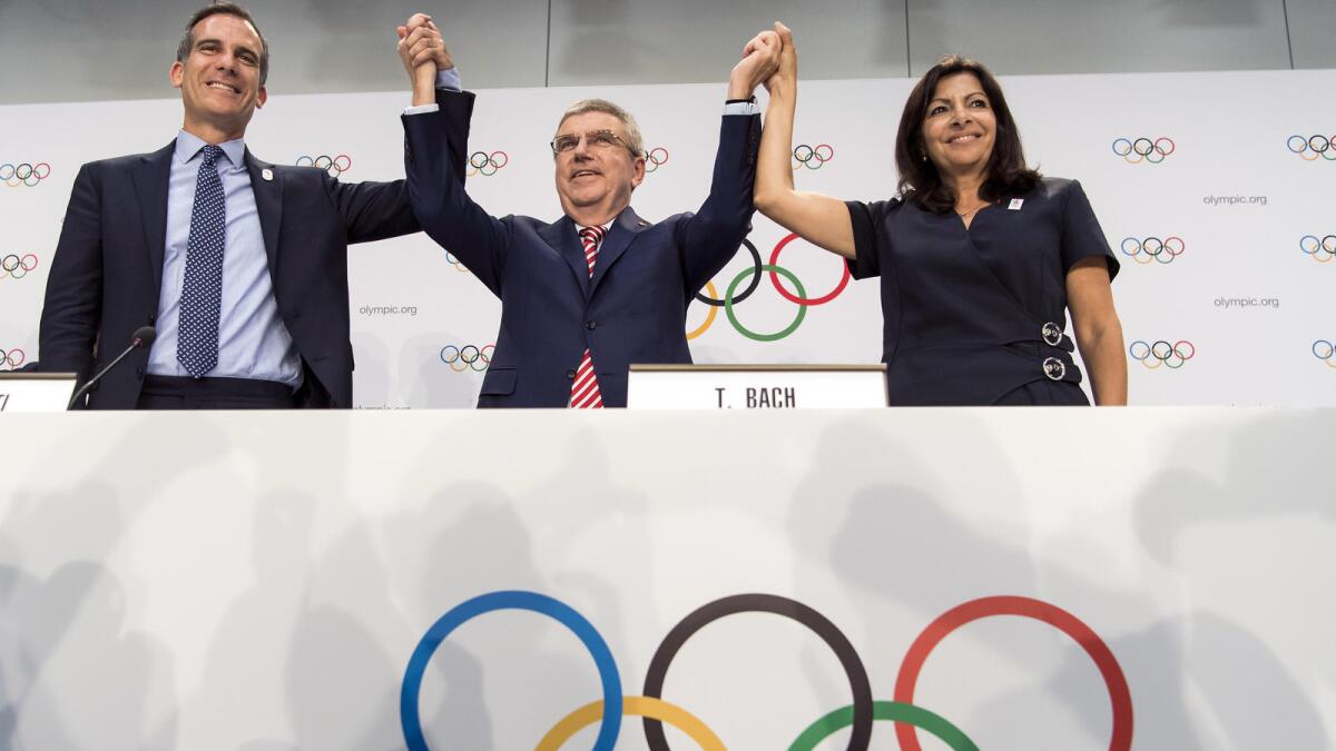 Los Angeles Mayor Eric Garcetti, left, celebrates with International Olympic Committee President Thomas Bach and Paris Mayor Anne Hidalgo.