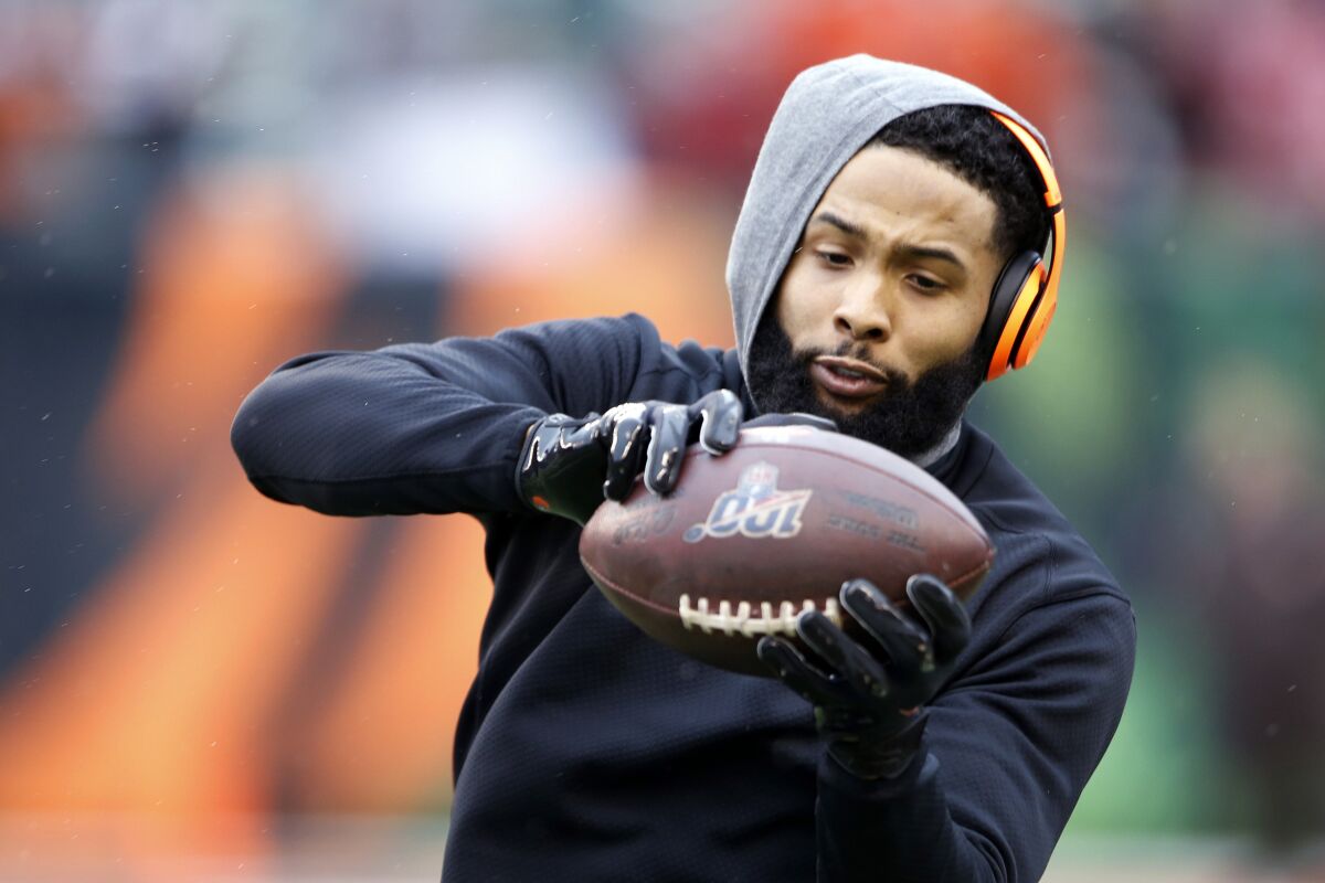 FILE - In this Dec. 29, 2019, file photo, Cleveland Browns wide receiver Odell Beckham Jr. catches a pass before an NFL football game against the Cincinnati Bengals in Cincinnati. Cleveland general manager Andrew Berry said Tuesday that Beckham has been fully committed to reporting to the team's facility. (AP Photo/Gary Landers, File)