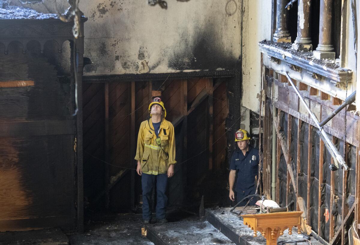 Los Angeles City firefighters look over the aftermath of a fire at St. Johns United Methodist Church