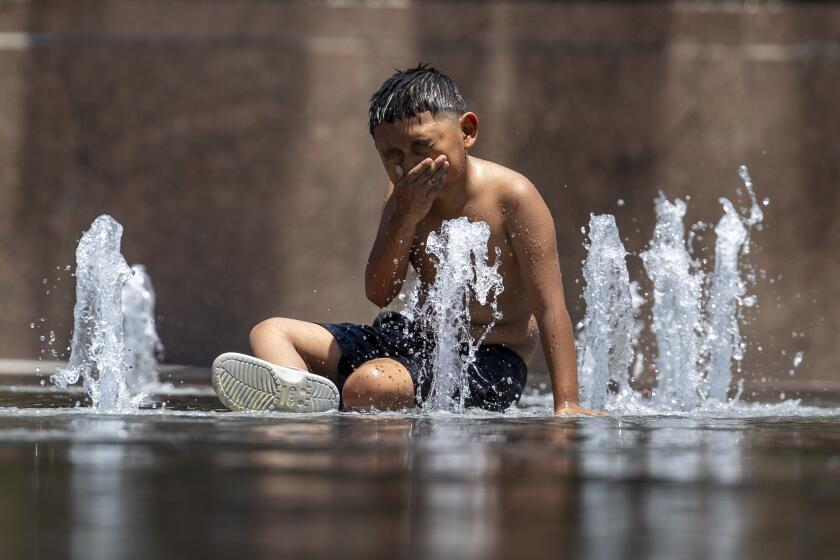 Los Angeles, CA - July 16: Gail Gomez plays in the water fountain at the Gloria Molina Grand Park in Los Angeles, CA on Tuesday, July 16, 2024. (Zoe Cranfill / Los Angeles Times)
