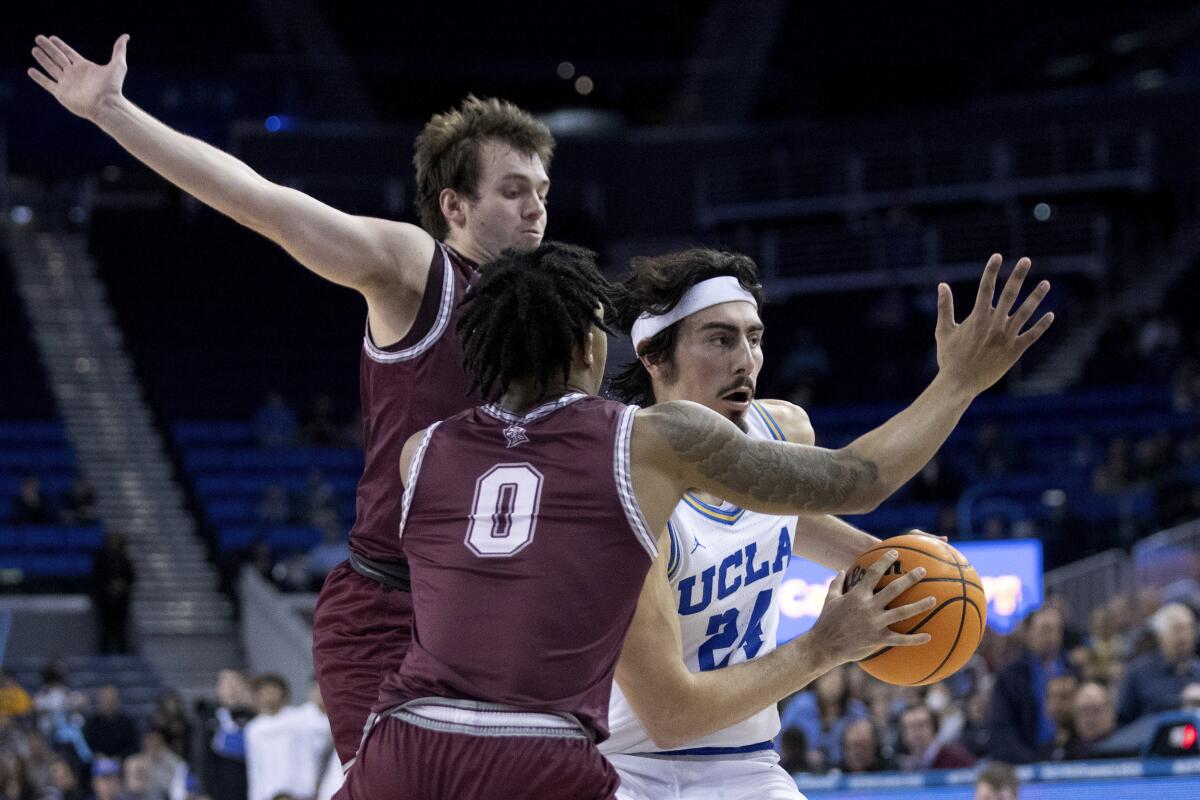 UCLA guard Jaime Jaquez Jr., right, looks to pass the ball away from Bellarmine guard Jaylen Fairman and guard Ben Johnson