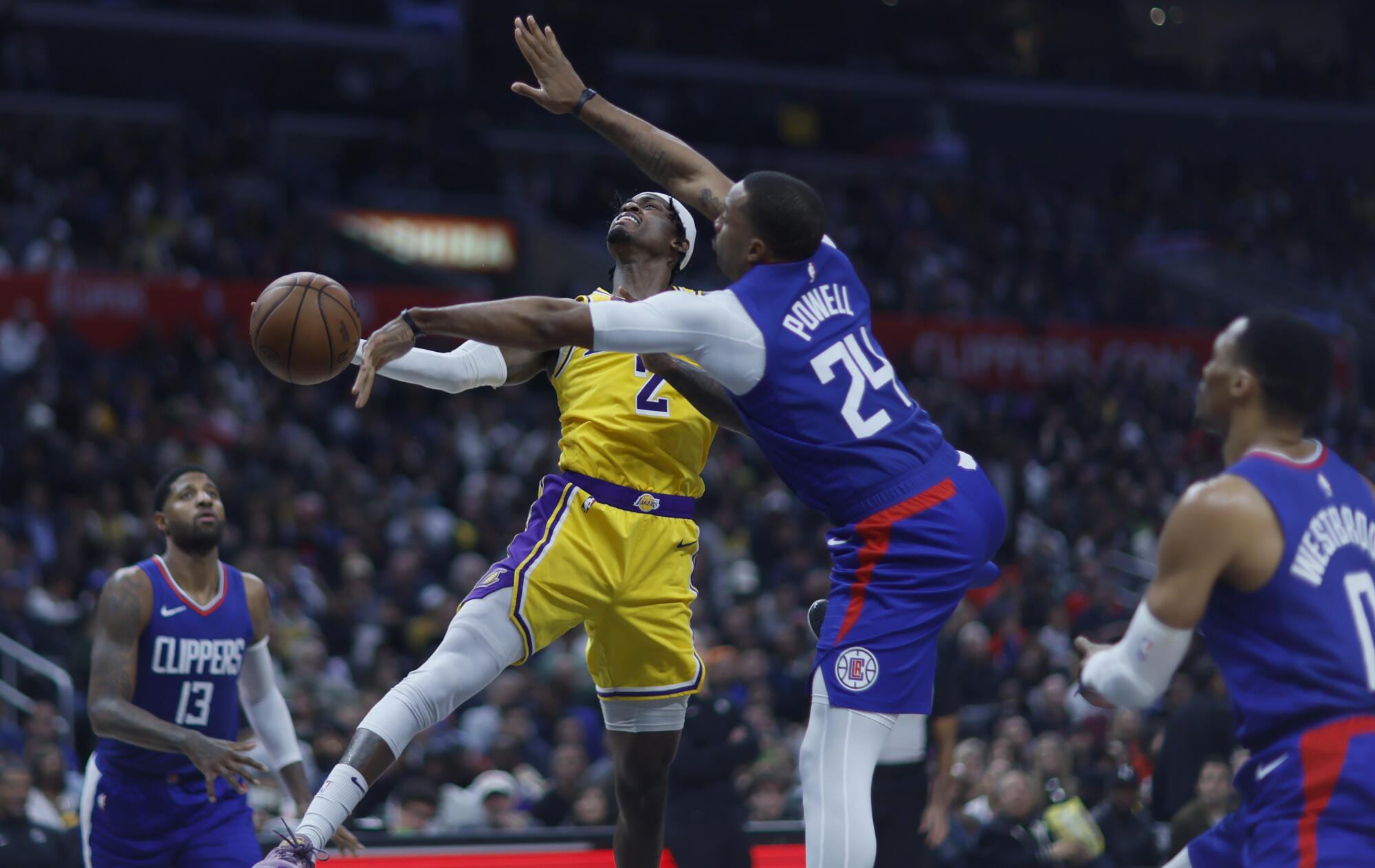 Clippers guard Norman Powell, center, blocks a shot by Lakers forward Jarred Vanderbilt during a game Jan. 23.