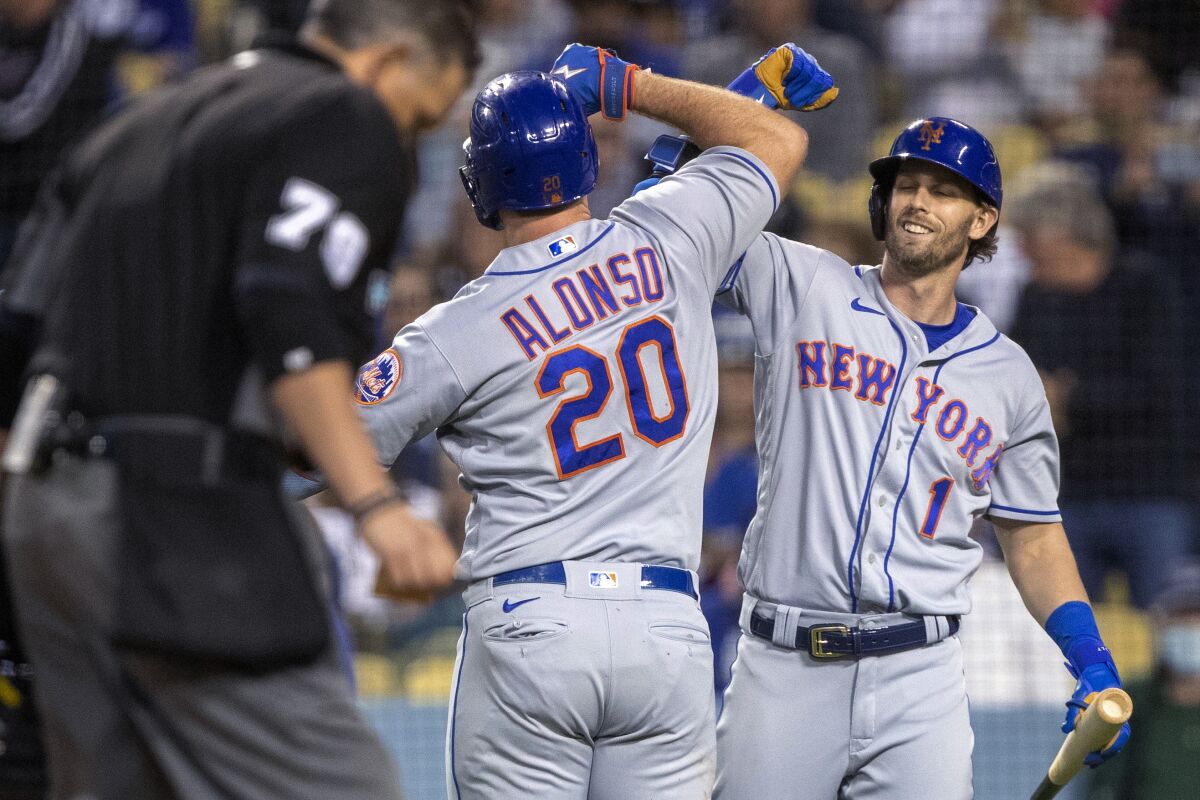 New York Mets' Jeff McNeil, right, congratulates Pete Alonso, who hit a two-run home run against the Los Angeles Dodgers during the third inning of a baseball game in Los Angeles, Saturday, June 4, 2022. (AP Photo/Alex Gallardo)