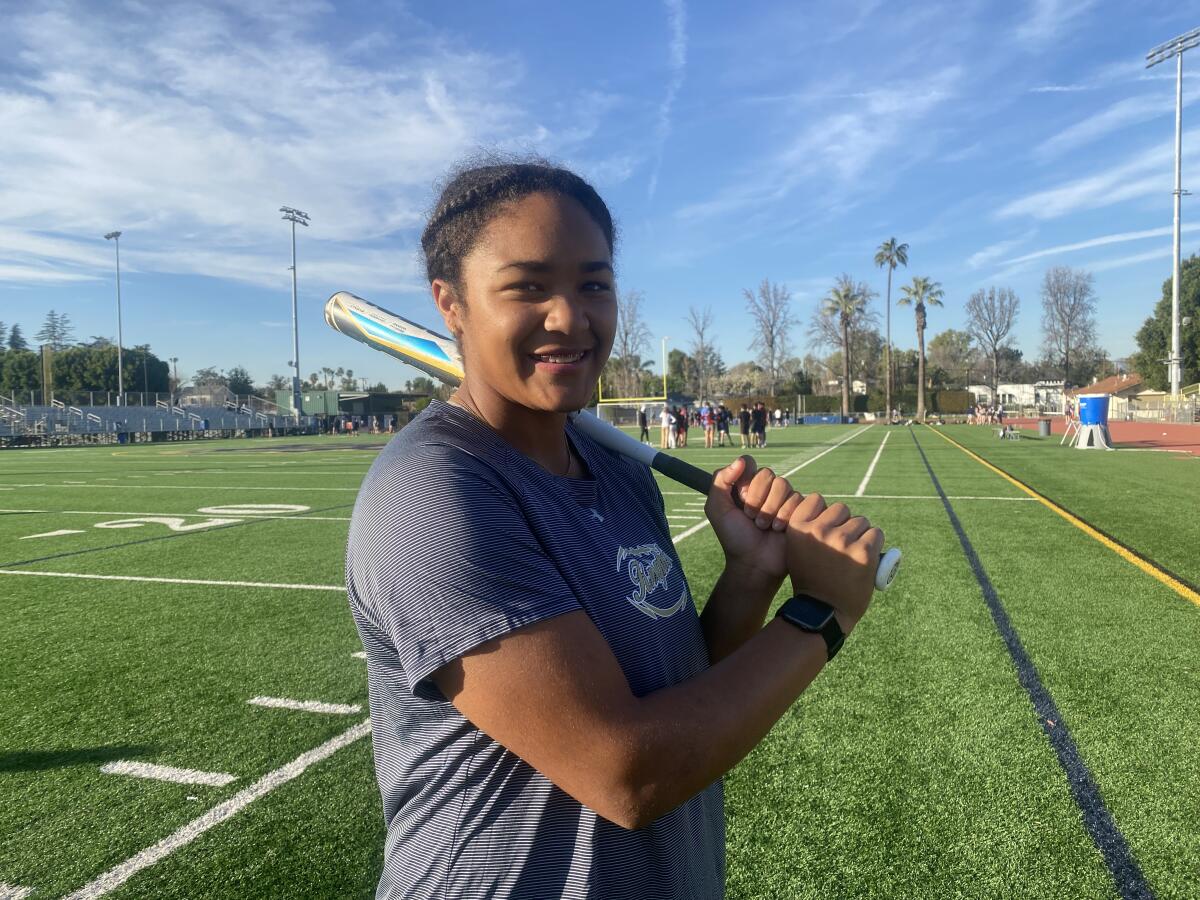 Sherman Oaks Notre Dame standout Ella Parker stands with a bat over her shoulder on a field.