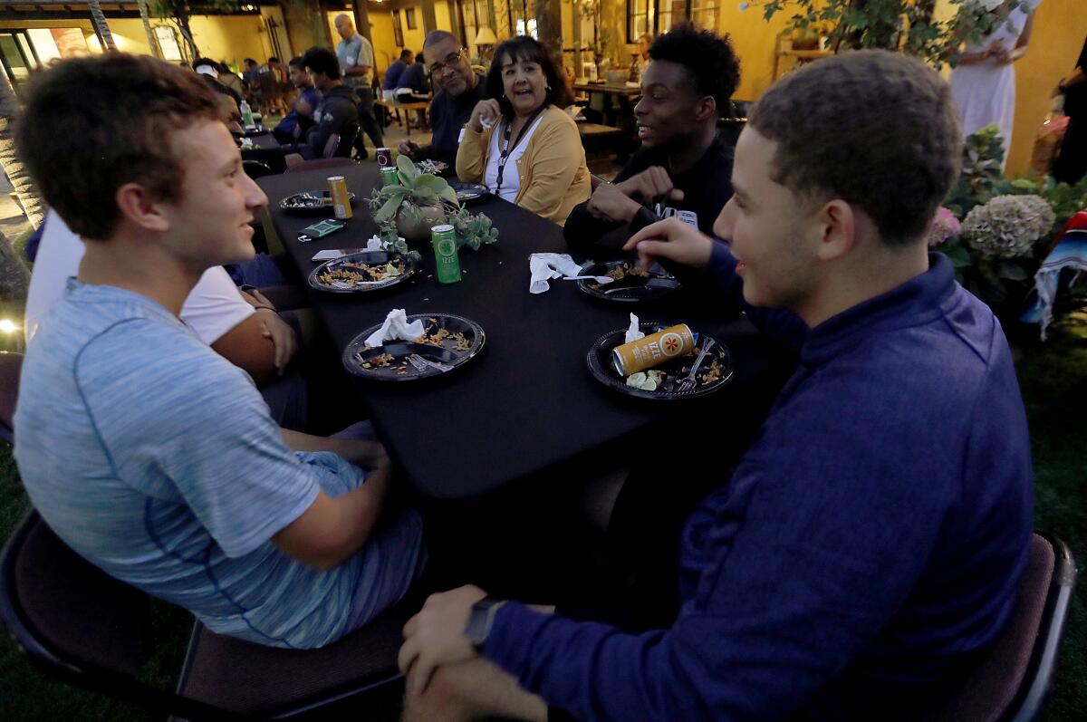 embers of the Chicago Hope Academy and Bishop Diego football teams talk over dinner on Sept. 19, 2019.