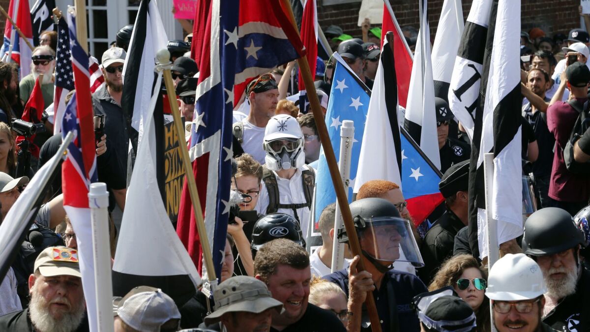 Surrounded by counterprotesters, white nationalist demonstrators walk into Lee Park in Charlottesville, Va., on Aug. 12, 2017.