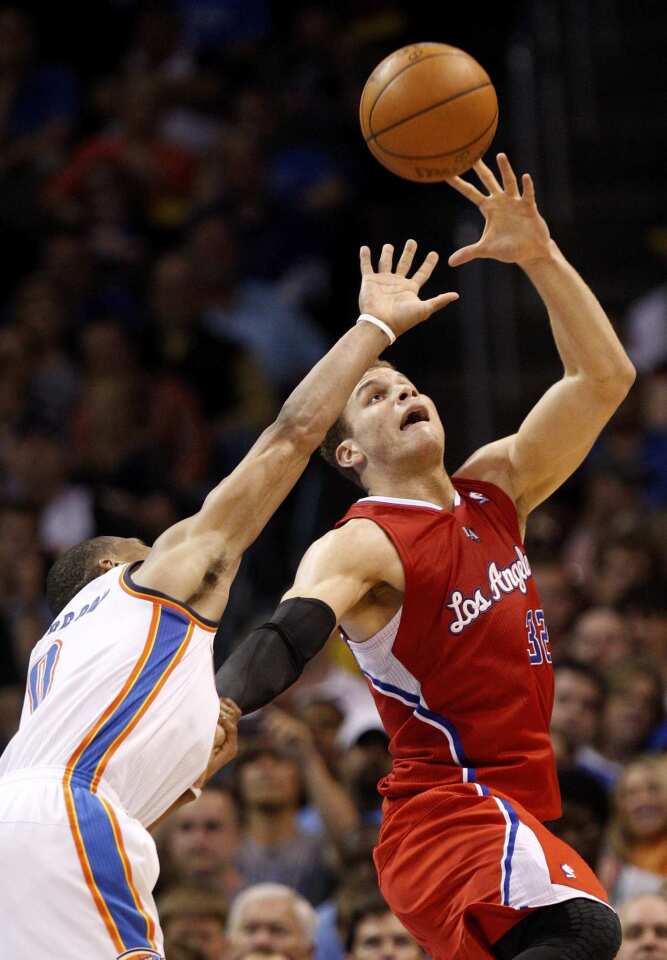 Clippers power forward hauls in a pass over the outstretched arm of Thunder point guard Russell Westbrook in the second half Wednesday night in Oklahoma City.