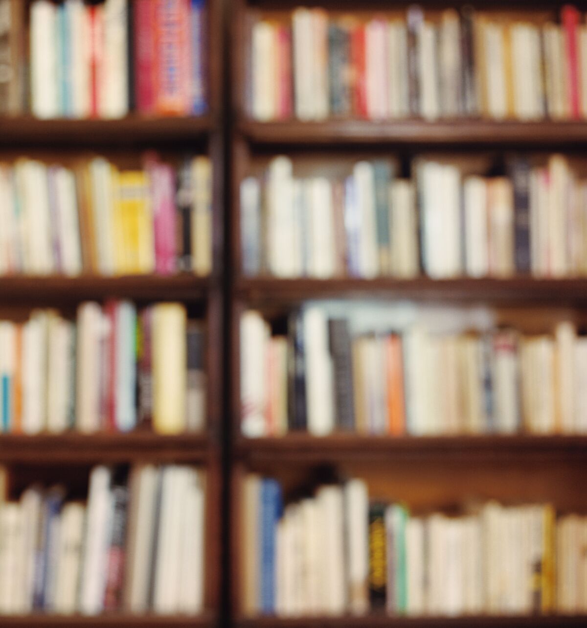 An out-of focus image shows books on a shelf.