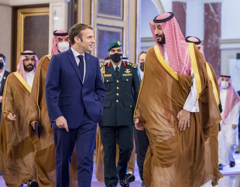 In this photo released by Saudi Royal Palace, Saudi Crown Prince Mohammed bin Salman greets French President Emmanuel Macron, left, upon his arrival in Jiddah, Saudi Arabia, Saturday, Dec. 4, 2021. (Bandar Aljaloud/Saudi Royal Palace via AP)