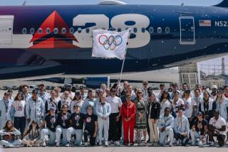 L.A. mayor Karen Bass and Gov. Gavin Newsom pose for a photograph with the official Olympic flag as it returns to LA