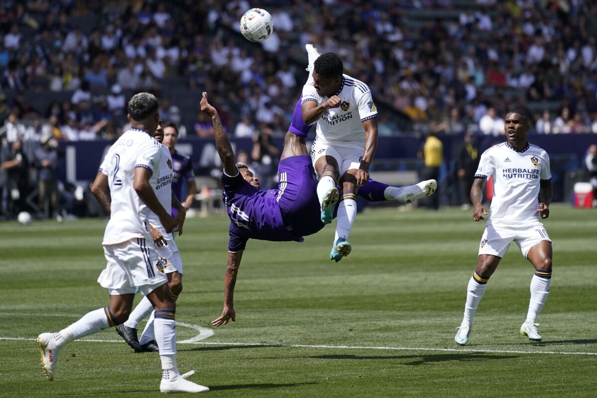 Orlando City midfielder Júnior Urso and Galaxy midfielder Rayan Raveloson collide.