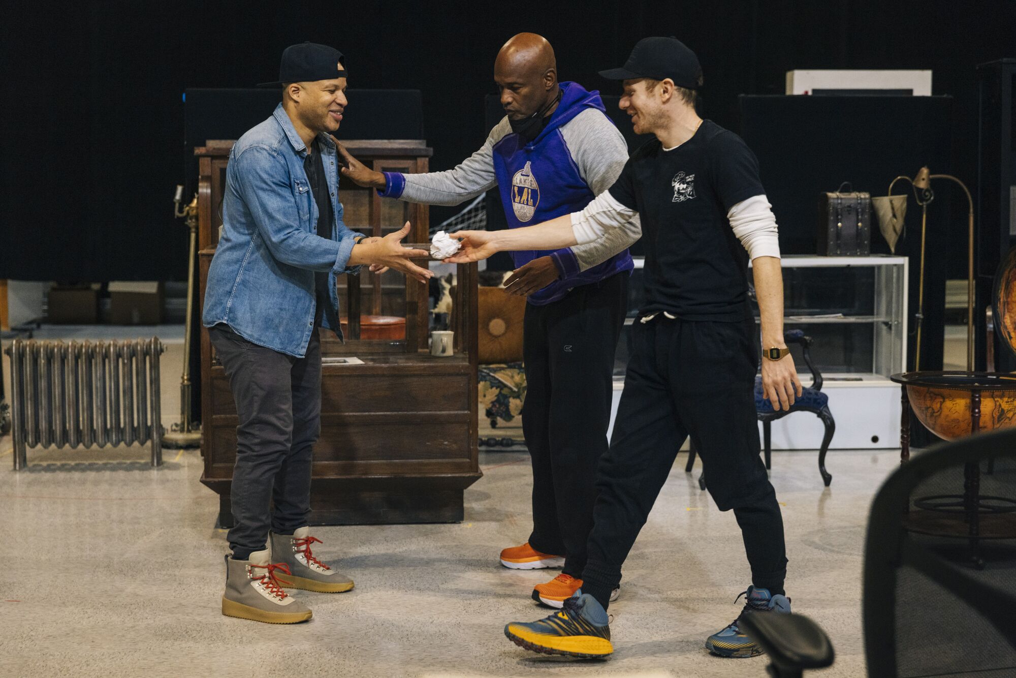 A director steps between two actors as he demonstrates what he wants them to do.