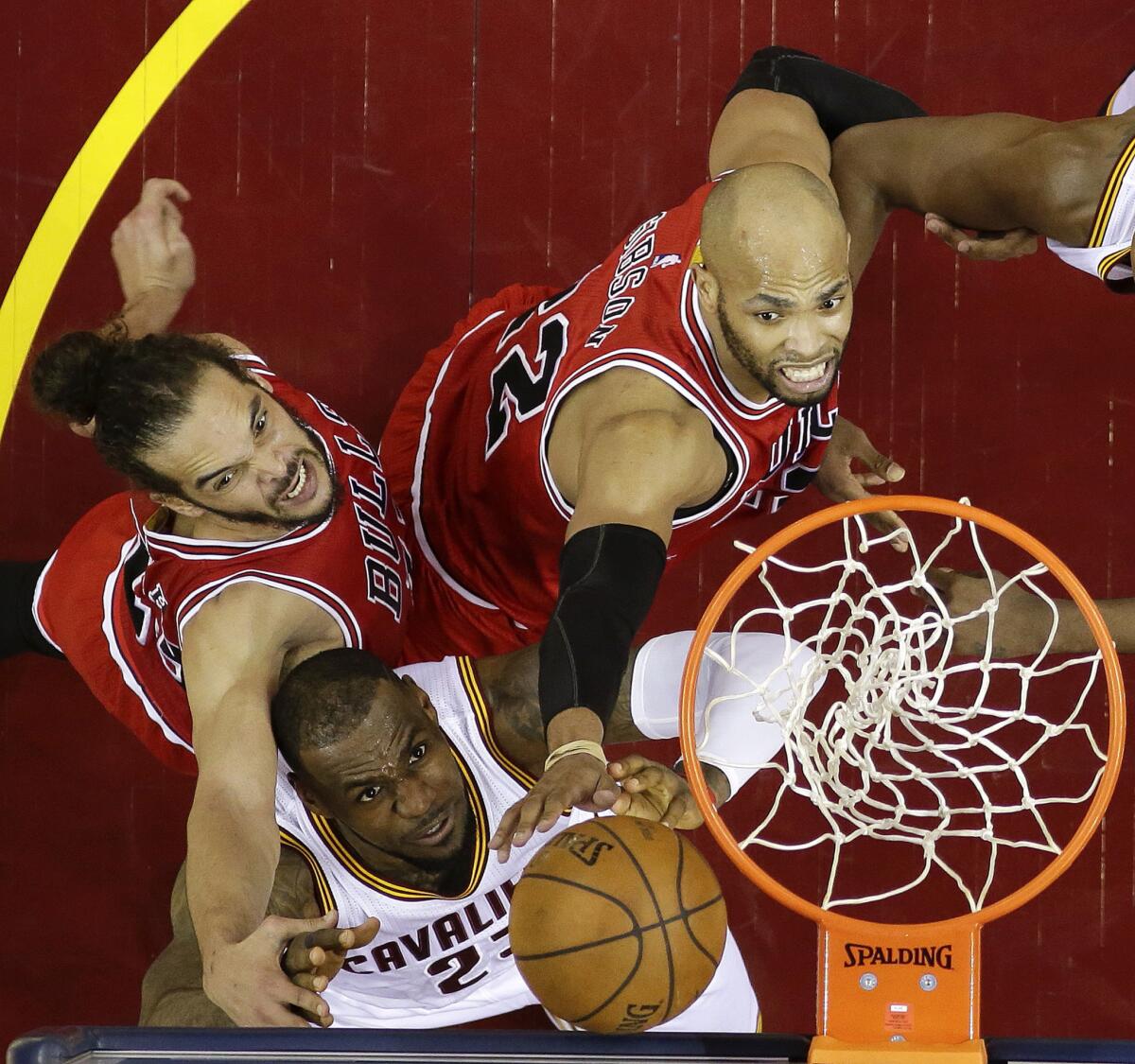 Bulls forwards Joakim Noah, left, and Taj Gibson, right, battle for a rebound under the basket with Cavaliers forward LeBron James during Game 1.