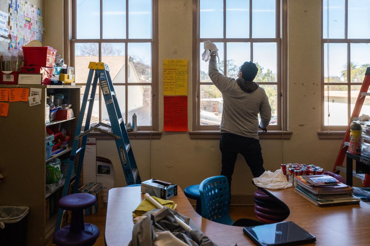 A contractor removes ash from a Jackson Elementary School classroom on Jan. 23.