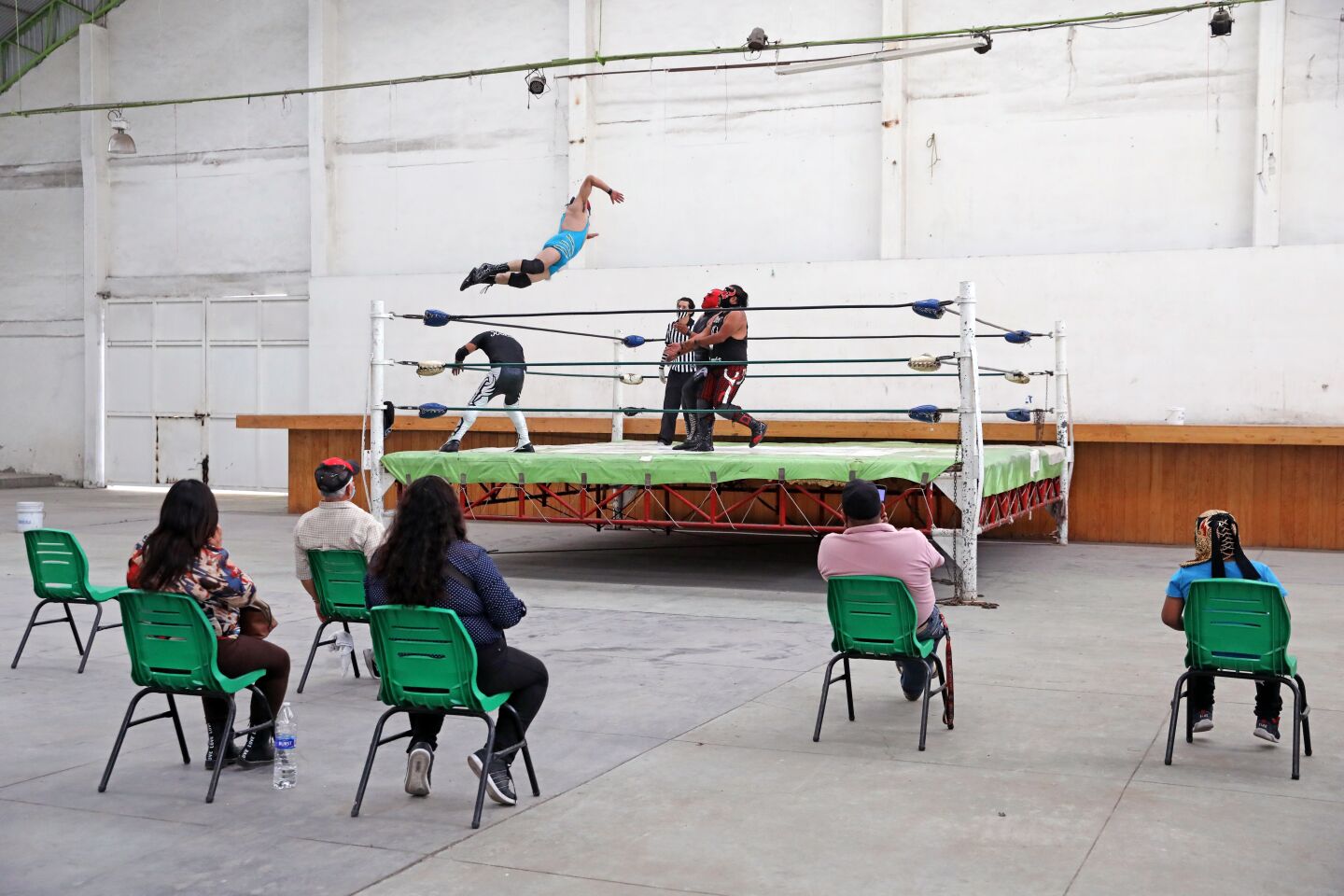 Physically distanced spectators watch Mr. Jack and Maldad wrestle at a lucha libre event that was broadcast online.