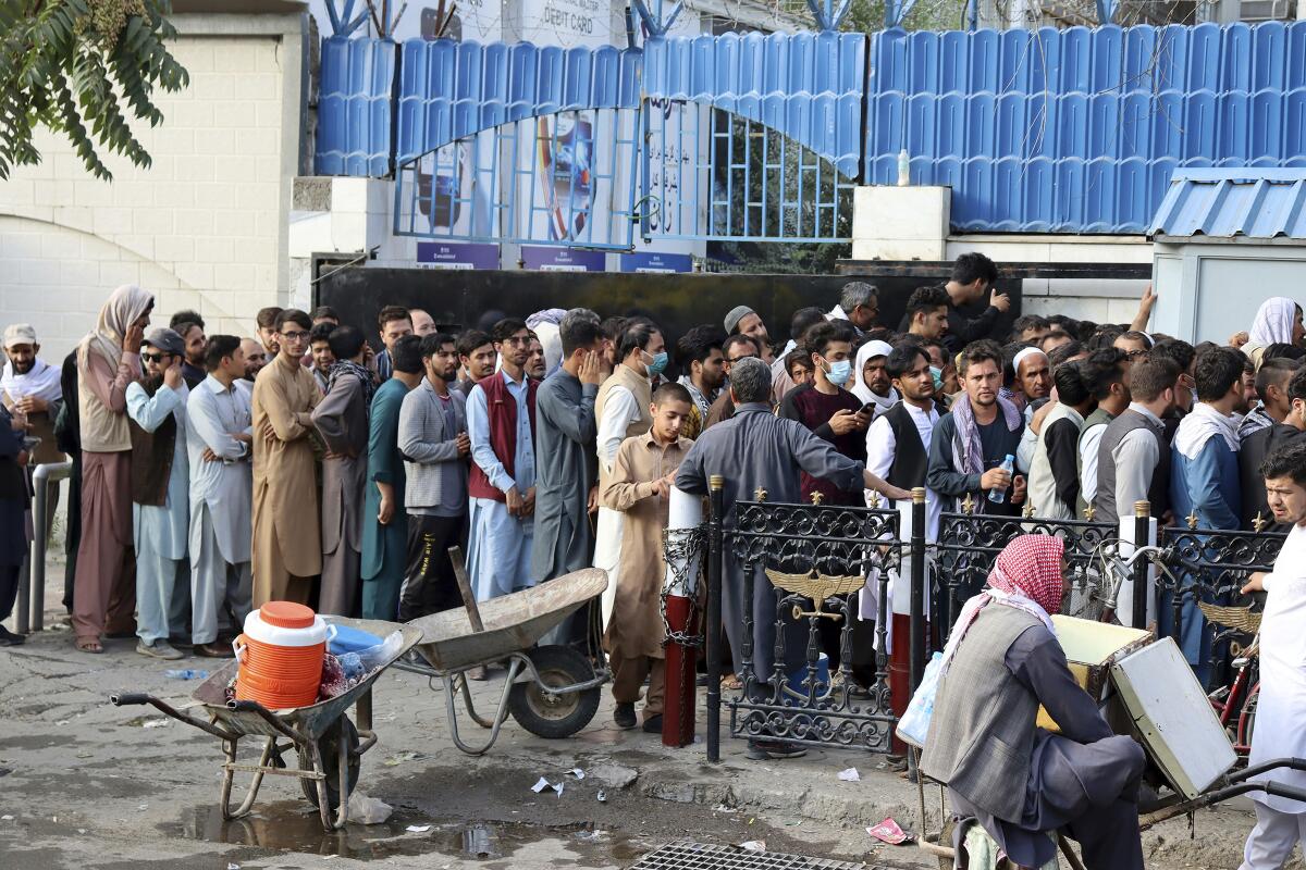 Afghans wait in long lines for hours to try to withdraw money in front of a bank in Kabul, Afghanistan on Monday.
