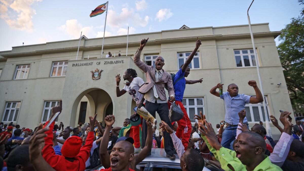 Zimbabweans celebrate outside the parliament building in November 2017 upon learning that President Robert Mugabe was leaving office.
