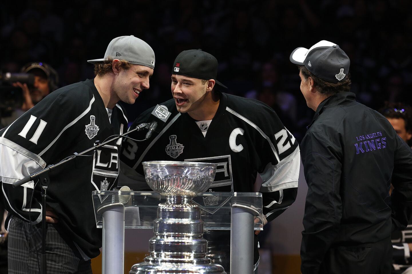 The Kings' Anze Kopitar, left, and Dustin Brown, center, with general manager Dean Lombardi during the rally at Staples Center.