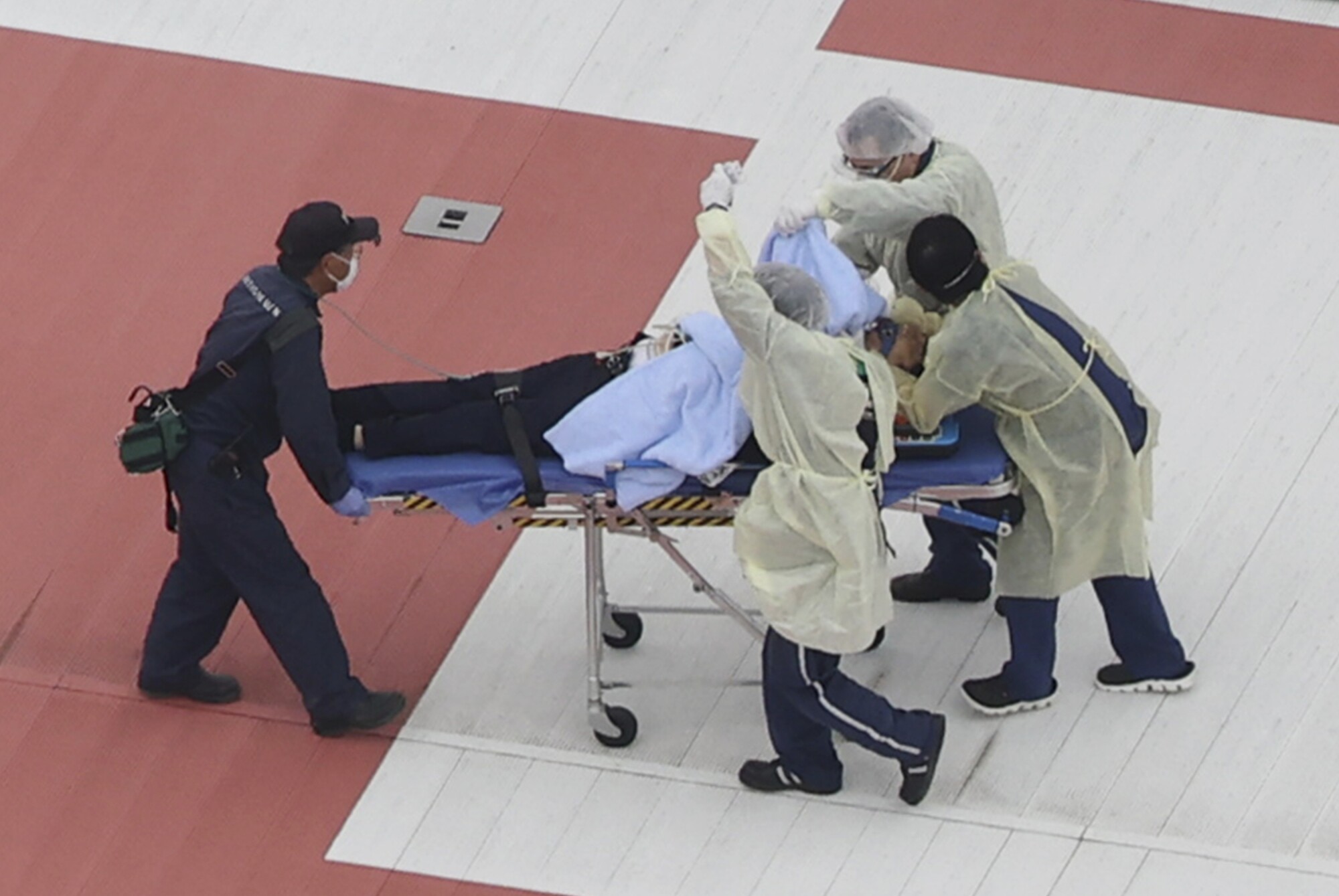 Abe is wheeled on a stretcher after arriving at a hospital on a helicopter