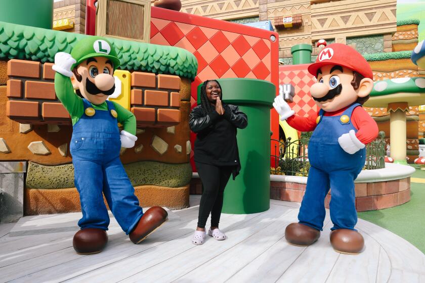 Los Angeles, CA - January 12: LJ Hale poses with Luigi and Mario at Super Nintendo World on Thursday, Jan. 12, 2023 in Los Angeles, CA. (Dania Maxwell / Los Angeles Times).