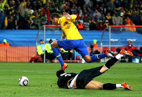 Luis Fabiano of Brazil jumps over Claudio Bravo of Chile to score his team's second goal during the teams' match at Ellis Park Stadium in Johannesburg, South Africa. Brazil won, 3-0.