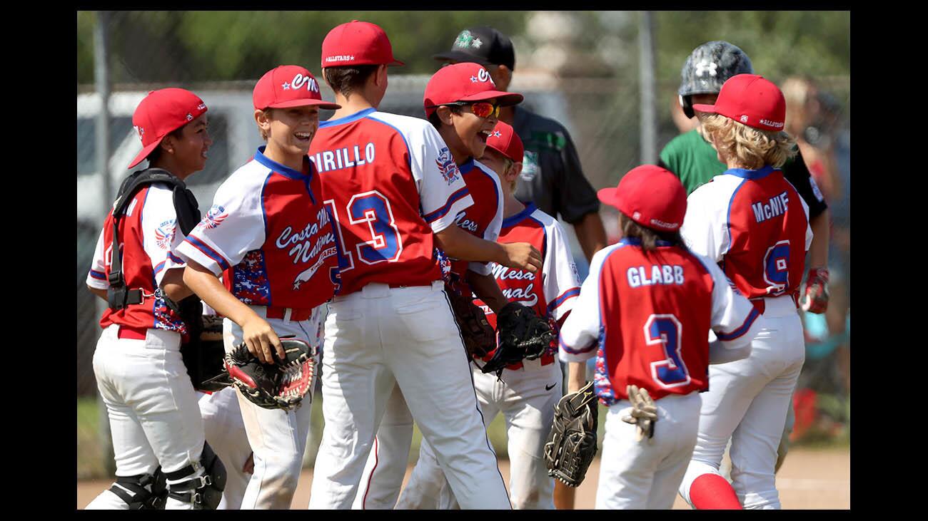 Costa Mesa Majors Division National Little League All-Stars players celebrate their win over American Little League All-Stars in decisive third game of the Mayor's Cup series, at TeWinkle Middle School in Costa Mesa on Saturday, July 14, 2018. Nationals won 2-0.