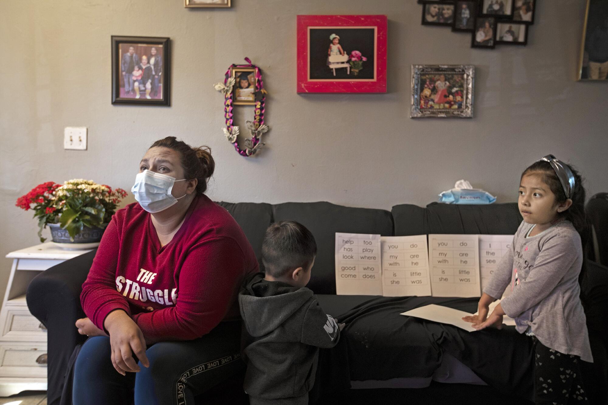 Ana Zuñiga Diaz sits beside two children