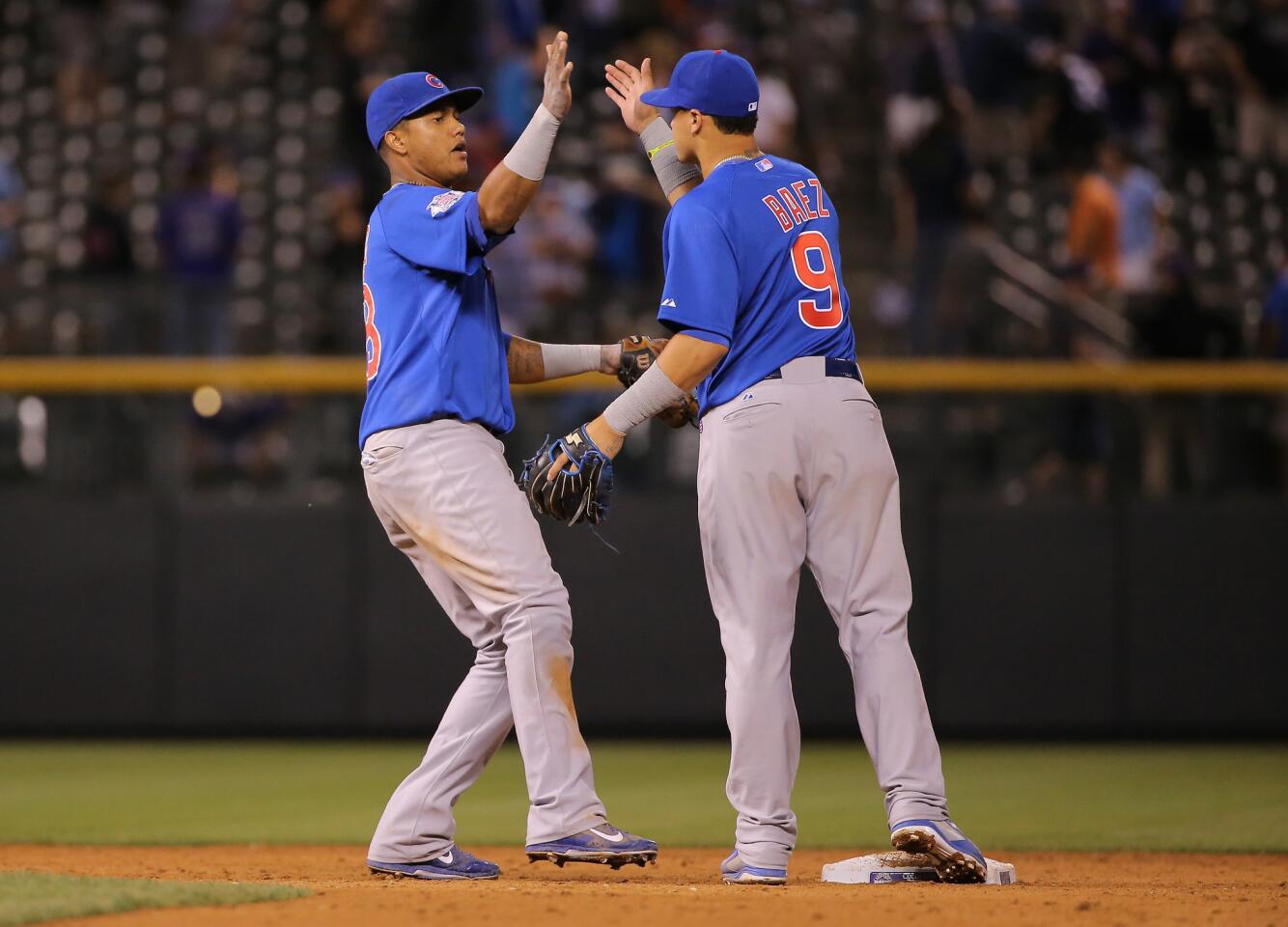 Starlin Castro and Javier Baez celebrate the Cubs' 6-5 victory in 12 innings at Coors Field.