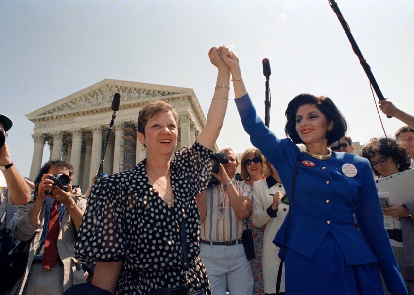 FILE - Norma McCorvey, Jane Roe in the 1973 court case, left, and her attorney Gloria Allred hold hands as they leave the Supreme Court building in Washington after sitting in while the court listened to arguments in a Missouri abortion case, April 26, 1989. A leaked draft of a U.S. Supreme Court decision suggests the country's highest court could be poised to overturn the constitutional right to abortion, allowing individual states to more heavily regulate or even ban the procedure. (AP Photo/J. Scott Applewhite, File)