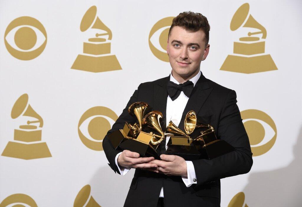 Sam Smith poses in the press room with the awards for best new artist, best pop vocal album, song of the year and record of the year for "Stay With Me" at the 57th annual Grammy Awards at the Staples Center on Sunday, Feb. 8, 2015, in Los Angeles.
