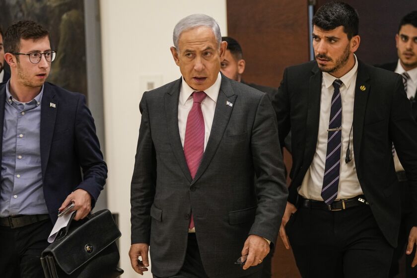 Israel's Prime Minister Benjamin Netanyahu walks at the Knesset, Israel's parliament, in Jerusalem, Wednesday, March 15, 2023. The Israeli army said Wednesday that soldiers killed an armed man suspected of entering the country from Lebanon and blowing up a car, raising the risk of renewed tensions with Hezbollah. The security situation in Israel prompted Netanyahu to cut short his two-day visit to Germany, his office said. (AP Photo/Ohad Zwigenberg)