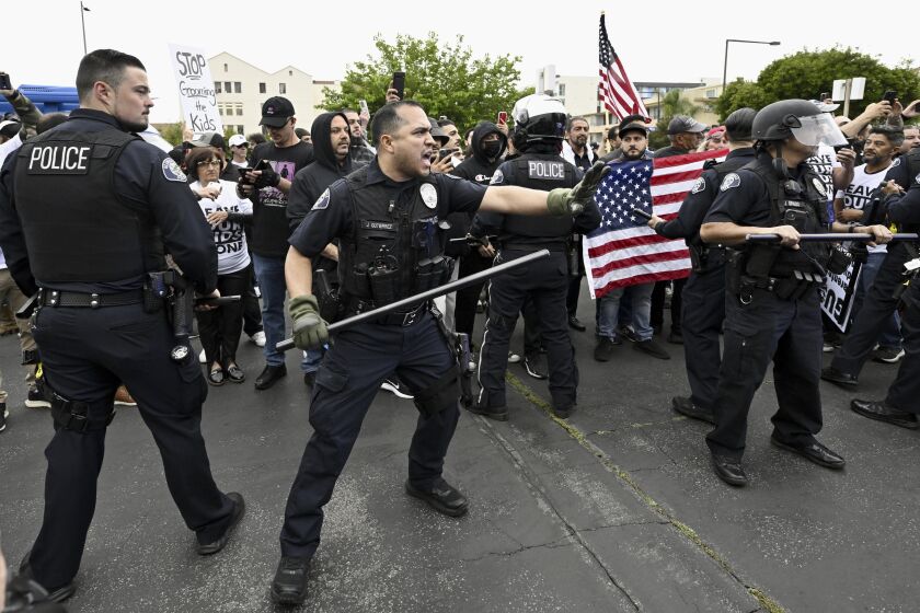 Conservative groups and LGBTQ+ rights supporters protest as police try to maintain order outside the Glendale Unified School District offices in Glendale, Calif., Tuesday, June 6, 2023. Several hundred people gathered in the parking lot of the district headquarters, split between those who support or oppose teaching about exposing youngsters to LGBTQ+ issues in schools. (Keith Birmingham/The Orange County Register via AP)