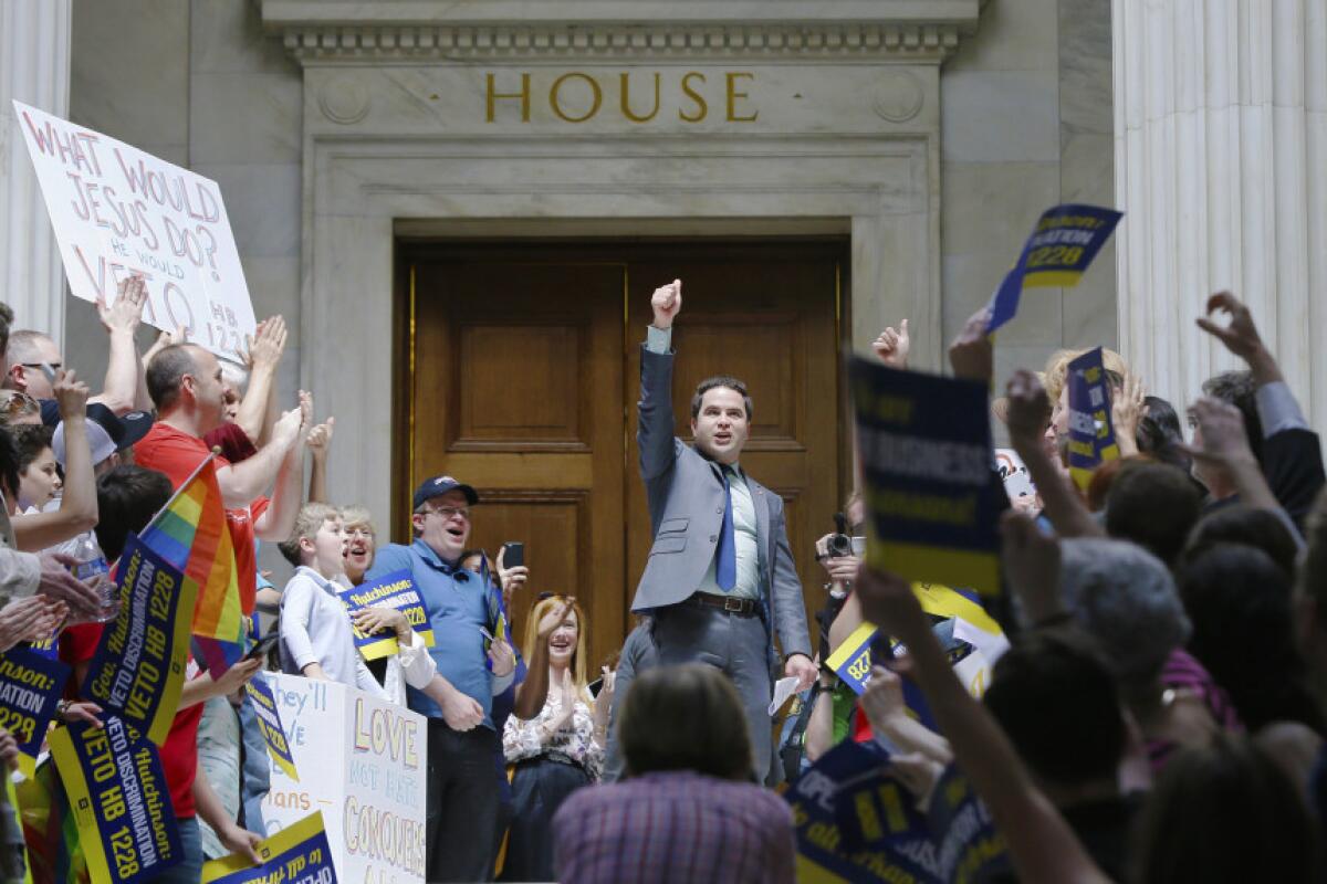 El representante demócrata Warwick Sabin (centro) se suma a manifestantes frente a la cámara baja de la Legislatura de Arkansas contra la aprobación de un proyecto de ley de objeción religiosa que según los detractores permitiría la discriminación de gays y lesbianas.