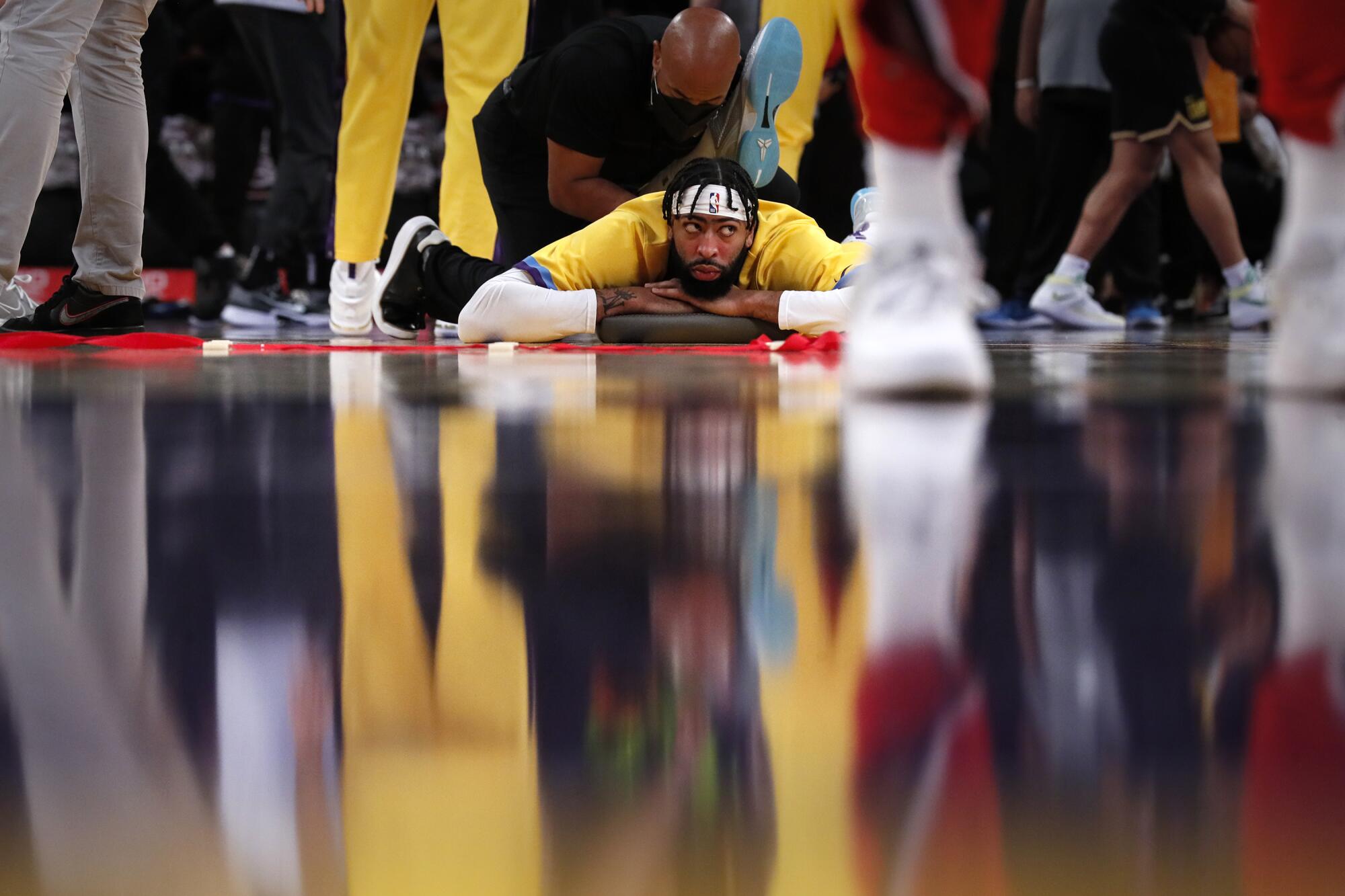 Lakers forward Anthony Davis stretches at midcourt before a game against the Chicago Bulls.
