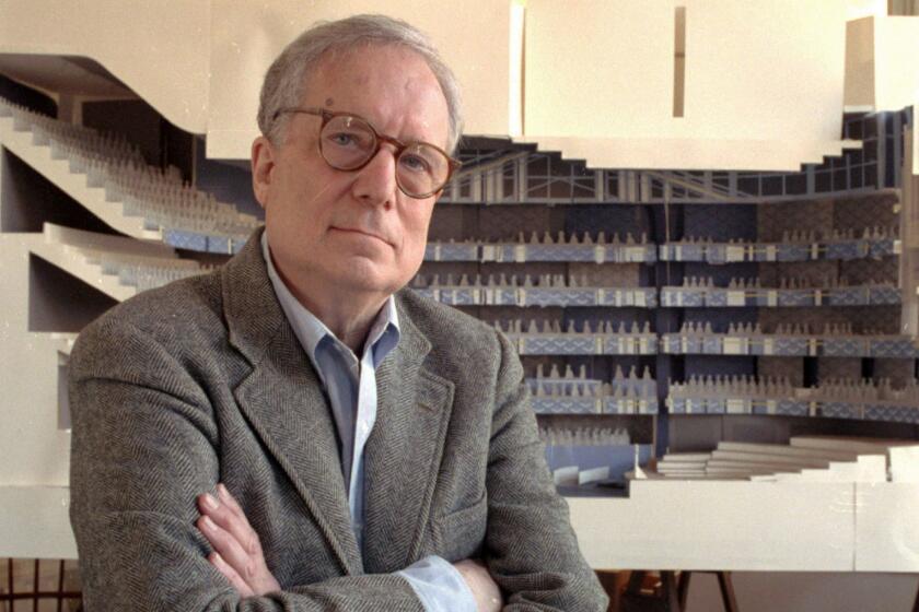 FILE - In this April 1991 file photo, architect Robert Venturi poses in his office in the Manayunk section of Philadelphia, with a model of a new hall for the Philadelphia Orchestra in background. Venturi, who turned austere modern design on its ear, ushering in postmodern complexity with the dictum "Less is a bore," has died. He was 93. His family released a statement on his firms website saying Venturi died at home in Philadelphia on Tuesday, Sept. 18, 2018, after a brief illness, and was surrounded by his wife and son. (AP Photo/George Widman, File)