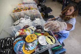 LOS ANGELES, CA-MARCH 1, 2023: Sandra Mims, a community health worker at Community Health Project LA, assembles kits that includes condoms, foreground, to be distributed to people that are unhoused in Los Angeles County. (Mel Melcon / Los Angeles Times)