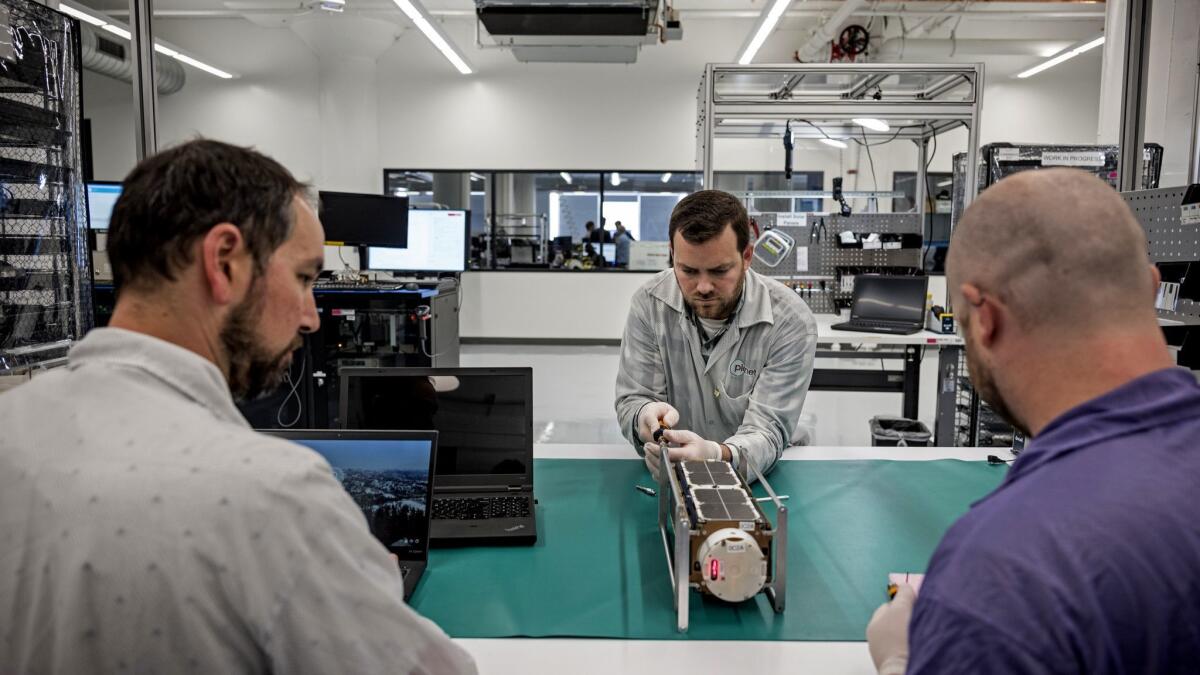 Engineers, left to right, Jacob Stern, Brent Amiano and Andrew Fisher test a satellite at one of the manufacturing and testing facilities of Planet, a San Francisco-based company that makes small satellites.