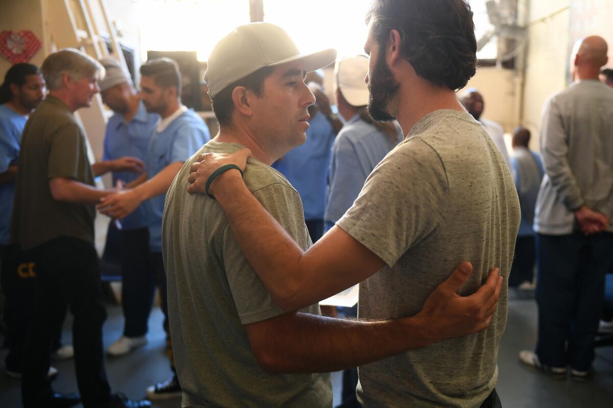 Jorge Heredia, an inmate, left, and Jesse Estrin, a facilitator, right, comfort one another during an emotional meeting, mourning the loss of Arnulfo Garcia at San Quentin State Prison. Christina House / Los Angeles Times