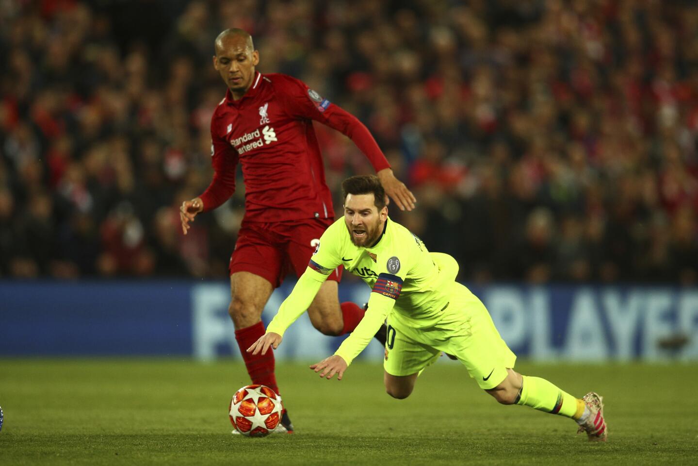 Lionel Messi del Barcelona cae cerca de Fabinho de Liverpool en el partido de vuelta de la semifinal de la Liga de Campeones, el martes 7 de 2019.