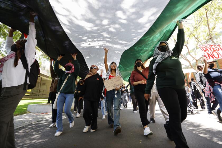 San Diego CA - May 8: Pro-Palestinian demonstrators walked through campus toward Matthews Quad at UC San Diego two days after an encampment was dismantled on Wednesday, May 8, 2024. (K.C. Alfred / The San Diego Union-Tribune)