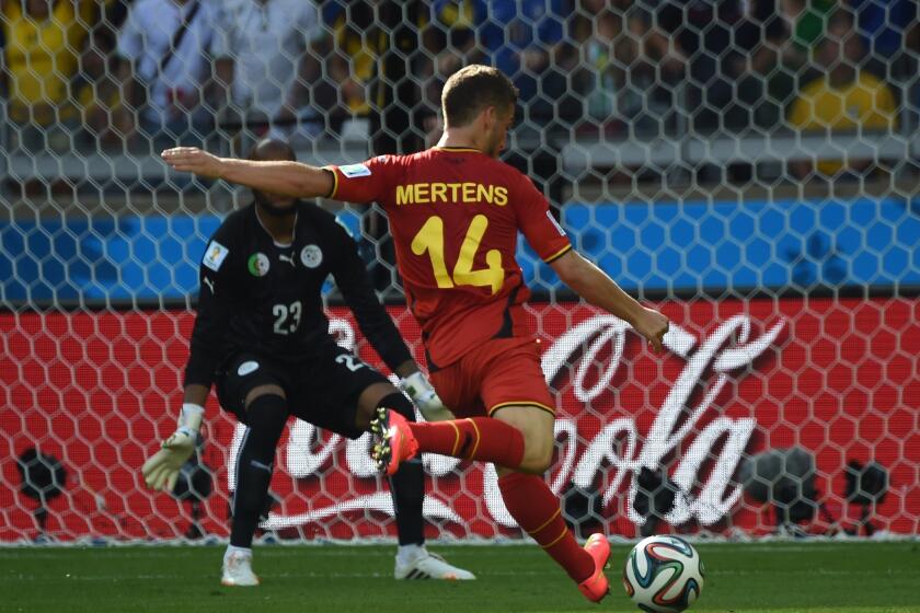 Belgium forward Dries Mertens scores against Algeria goalkeeper Rais Mbohli during a Group H World Cup match Tuesday at the Mineirao Stadium in Belo Horizonte, Brazil.