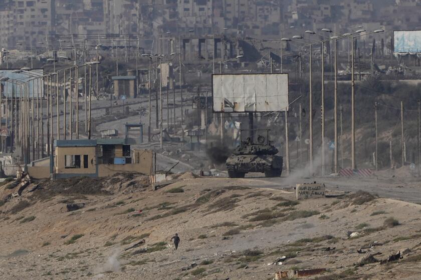 A Palestinian runs away from an Israeli tank in the central Gaza Strip on Sunday, June 9, 2024. (AP Photo/Abdel Kareem Hana)